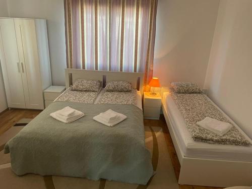 a bedroom with two beds with towels on them at Csilla Vendégház Remete in Remetea