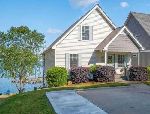 a white house with a driveway next to the water at 43 Making Memories in Leesburg
