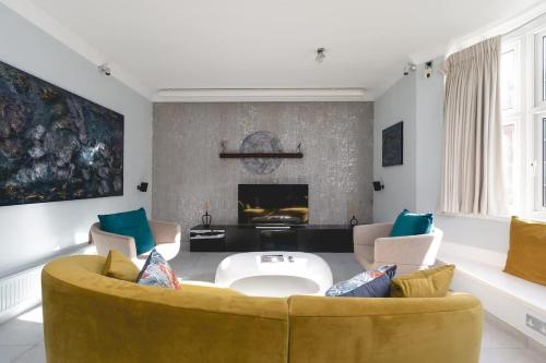 a living room with a yellow couch and a fireplace at Regent's Park 1 bed with terrace in London