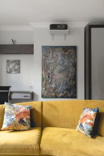 a yellow couch in a room with a painting on the wall at Regent's Park 1 bed with terrace in London