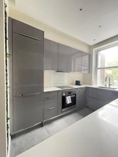 a kitchen with stainless steel appliances and a large window at Regent's Park 1 bed with terrace in London