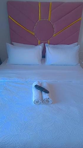 a remote control sitting on top of a bed at white house Bluewaterbay in Gqeberha
