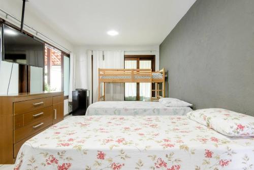 a bedroom with two beds and a dresser at Pousada Queiroz in Barra da Tijuca