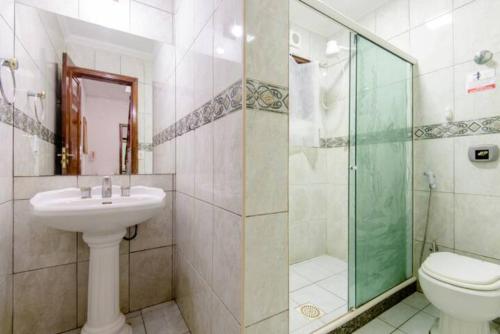 a bathroom with a toilet and a sink and a shower at Pousada Queiroz in Barra da Tijuca