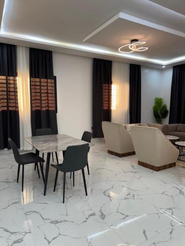 a living room with a table and chairs and a couch at Samaris Résidences in Nouakchott