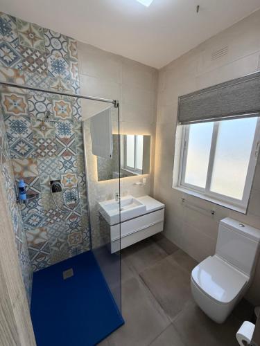 a bathroom with a toilet and a sink and a shower at Serenità - Seaview Penthouse in Marsaskala