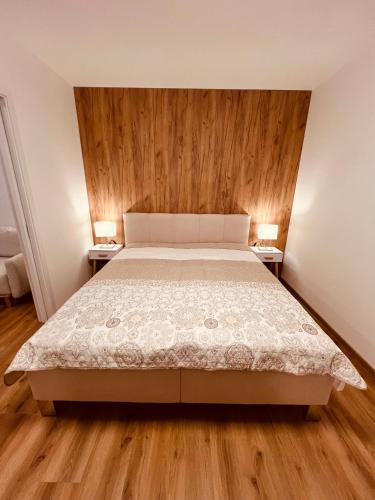 a bedroom with a bed and two lamps on two tables at PORTA Apartment in Františkovy Lázně