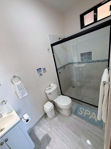 a bathroom with a shower and a toilet and a sink at STELLA MARIS Boutique Hotel in El Sargento