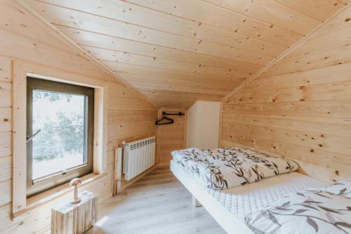 a bedroom with a bed in a wooden room at Cisza Traw in Rabka-Zdroj