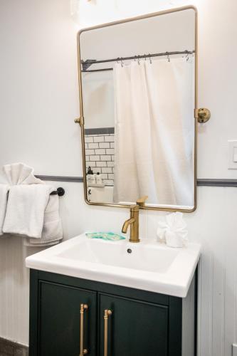 a bathroom with a white sink and a mirror at Luxe Mid-Century Styled Historic Townhouse #1 in Detroit