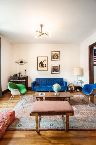 a living room with a blue couch and chairs at Luxe Mid-Century Styled Historic Townhouse #1 in Detroit