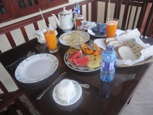 a table with plates of food and drinks on it at Sapara River Guest in Bentota
