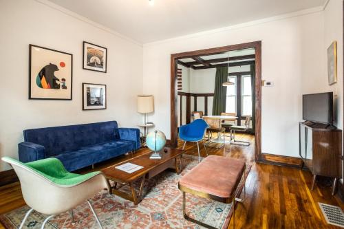 a living room with a blue couch and chairs at Luxe Mid-Century Styled Historic Townhouse #1 in Detroit