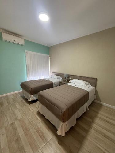 two beds in a room with blue walls at Apart Altos Del Pilar in Pilar