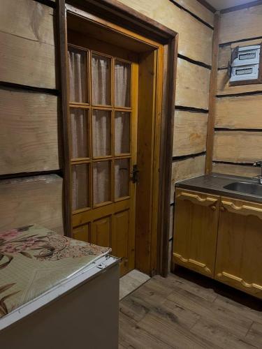 a bathroom with a sink and a wooden door at Pryhirska Sadyba in Torunʼ
