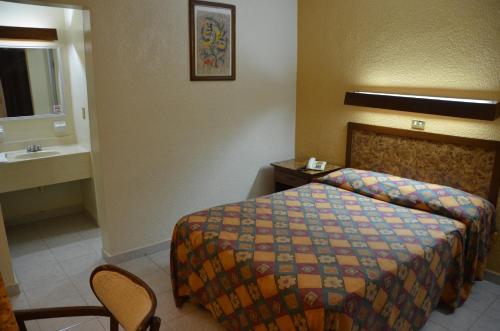 a hotel room with a bed and a sink at Motel los Alpes in Ciudad Acuña