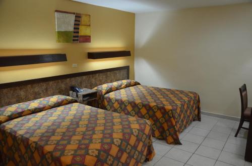 a hotel room with two beds in a room at Motel los Alpes in Ciudad Acuña