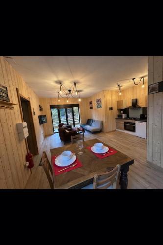 a kitchen and living room with a table and chairs at Grange de l'ancienne école avec Jacuzzi privé in Gérardmer