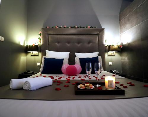 a bedroom with a bed with a table with wine glasses at Luxury & Love - Professional Jaccuzzi and Spa in Chelles
