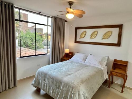 a bedroom with a bed and a large window at Casa Cerezos in Ica