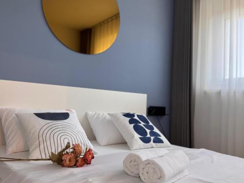 a white bed with blue and white pillows and a mirror at M2Suites by BestChoice - Messe - Parking - Self-Check-in in Graz