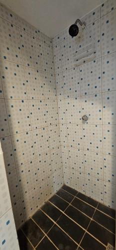 a bathroom with a tiled wall with a shower at Habitación en villa Costa del sol in Los Blancos