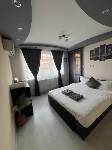 a bedroom with a large bed and a large window at Apartament Kamarashki in Troyan