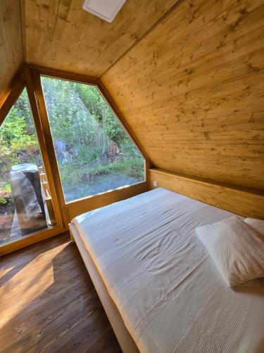 a bed in a small room with a window at Hillside Cabin in Pomezí