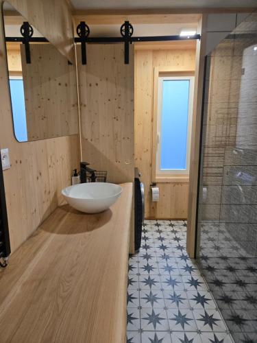 a bathroom with a large white sink and a shower at Hillside Cabin in Pomezí