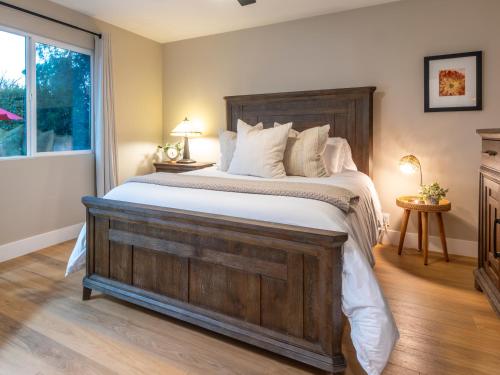 a bedroom with a large wooden bed with white pillows at Folsom Old Town Escape in Folsom