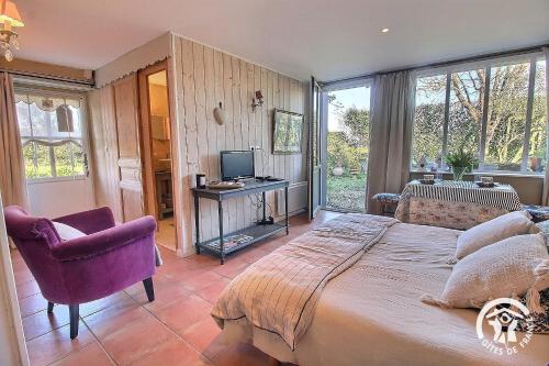 a bedroom with a bed and a chair and a television at Chez patricia in Ploubazlanec