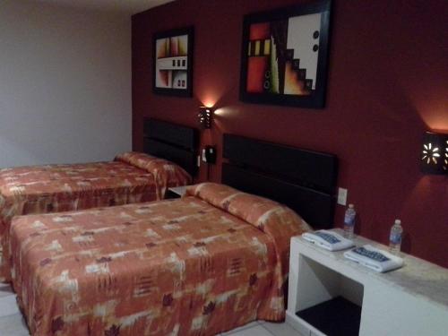 a hotel room with two beds and a table at La Quinta Puebla in Puebla