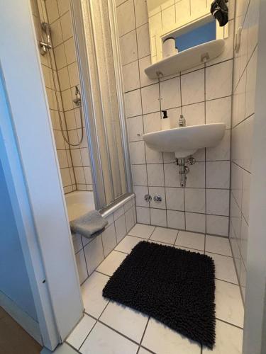 a small bathroom with a sink and a mirror at Zimmer-Bad-TV-Kühlschrank-16 in Meine