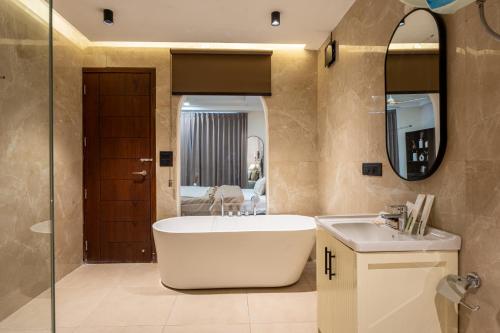 a bathroom with a tub and a sink and a mirror at The Hi-Rise in Gurgaon