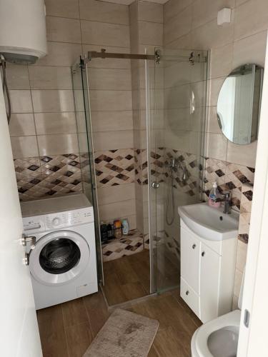 a bathroom with a washing machine and a sink at Central in Pančevo