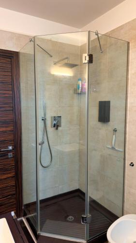 a shower with a glass door in a bathroom at Giulia By The Sea in Follonica