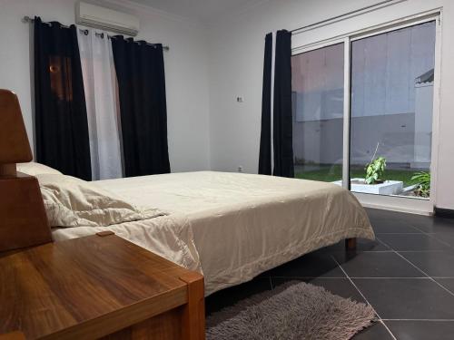 a bedroom with a bed and a large window at Casa da Lua, com espaço gourmet no Lubango, Huila in Lubango