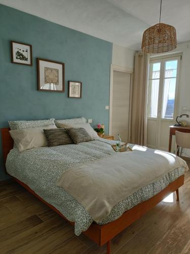 a bedroom with a large bed with a blue wall at B&B Barba Vigin in San Damiano dʼAsti