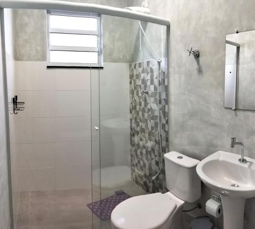 a bathroom with a shower and a toilet and a sink at Kitnet Moderna com Ar e Vaga Privativa Coberta in Votorantim