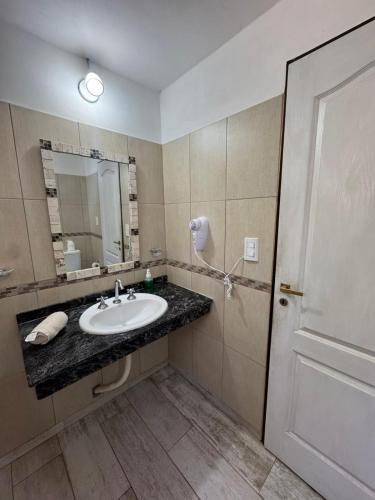 a bathroom with a sink and a mirror at El Cantar de los Pajaros in Merlo