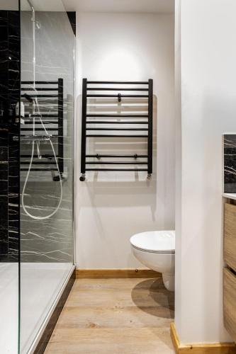 a bathroom with a toilet and a glass shower at L'Alpage - Serre Chevalier in Saint-Chaffrey