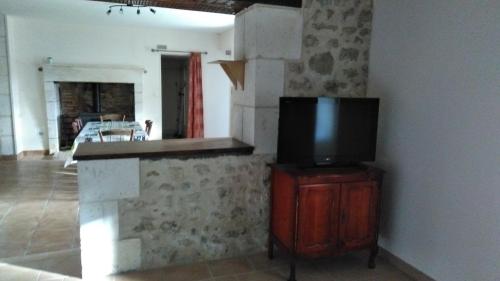 a living room with a tv on a wooden stand at Le Gîte de Mayac,16 rue du four à pain, 24600 VILLETOUREIX FRANCE in Villetoureix