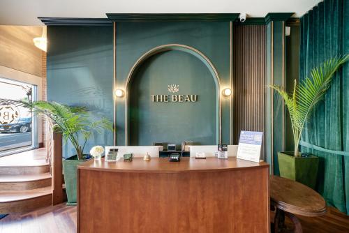 a reception desk in a room with a green wall at The Beau Hotel Downtown San Diego Gaslamp Quarter in San Diego