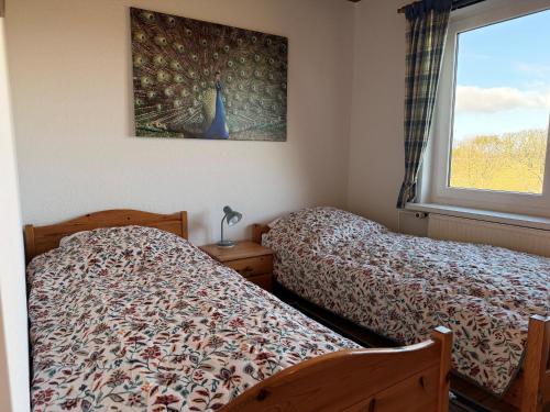 a bedroom with two beds and a window at Haus Ruhewinkel, Bungalow 2 in Alkersum