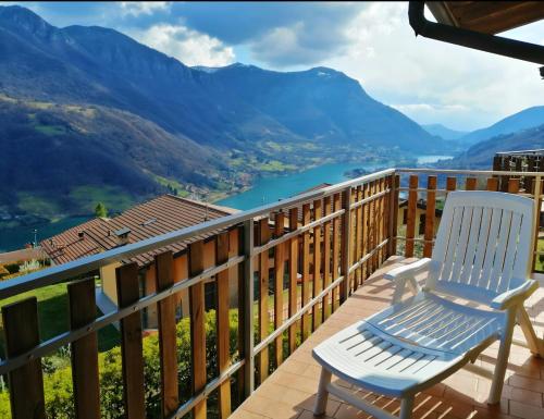 a chair on a deck with a view of a river at La Magia del Lago in Ranzanico