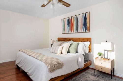 a bedroom with a bed with white sheets and pillows at Huge 4 Bedroom House Near Square One - Sleeps 8 in Mississauga