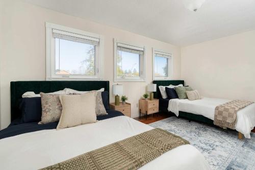 a bedroom with two beds and two windows at Huge 4 Bedroom House Near Square One - Sleeps 8 in Mississauga