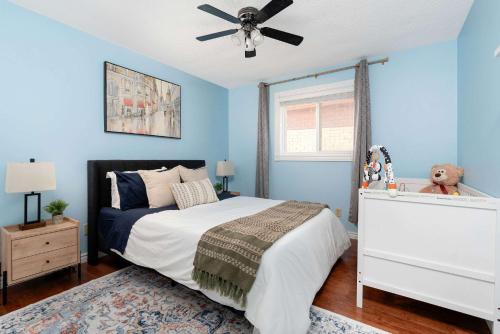 a bedroom with blue walls and a bed with a ceiling fan at Huge 4 Bedroom House Near Square One - Sleeps 8 in Mississauga