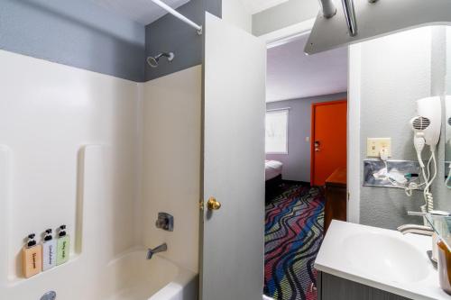 a bathroom with a tub and a sink at Sunset Motel and RV in Alliance