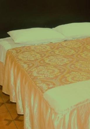 a bed with an orange blanket and white pillows at Valeria Victoria in Los Limos